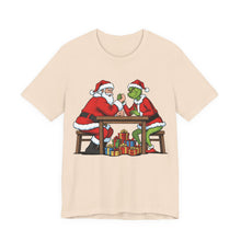Load image into Gallery viewer, Santa vs The Grinch – Funny Christmas Graphic Tee (Unisex) Soft Cream
